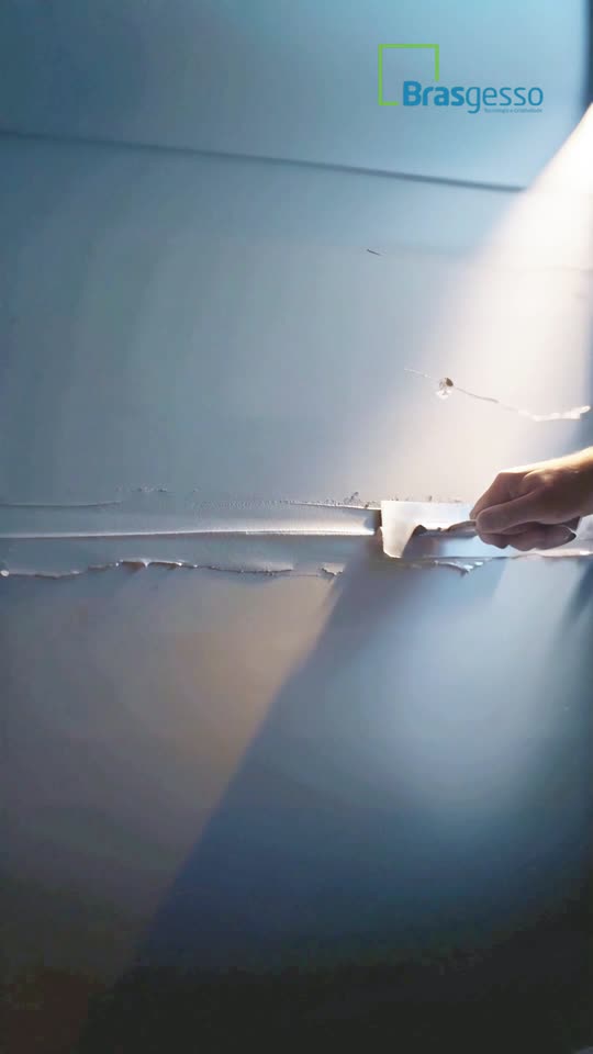 Cena do comercial Brasgesso com aplicação de massa em uma parede